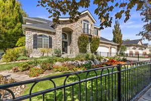 View of front of home with stone siding, a shingled roof, an attached garage, and concrete driveway