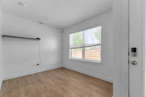 Unfurnished room with light wood-style flooring and a smoke detector