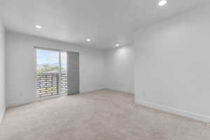 Unfurnished room with light colored carpet and recessed lighting