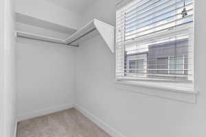 Walk in closet featuring light colored carpet