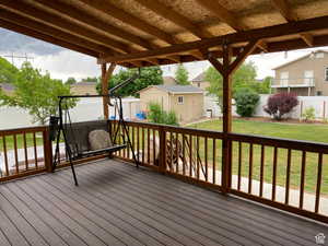 Deck featuring a fenced backyard and a shed