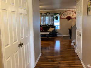 Hall featuring dark wood-style flooring and crown molding