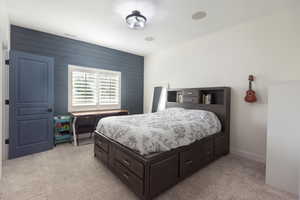 Bedroom featuring wood walls and light colored carpet