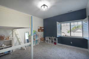 Carpeted bedroom featuring wooden walls