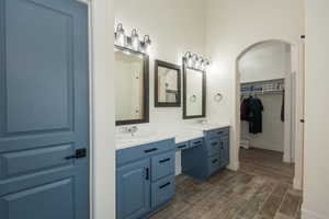 Full bath with wood tiled floors, double vanity, and a walk in closet