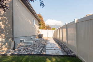 View of side of property with a fenced backyard, stucco siding, and a mountain view