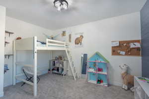 Bedroom featuring light carpet