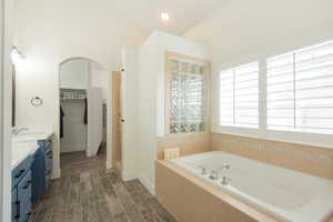 Full bathroom with vanity, a garden tub, wood tiled floors, recessed lighting, and a shower stall
