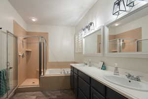 Bathroom with a bath, a shower stall, and double vanity