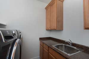 Laundry area featuring washing machine and clothes dryer and cabinet space