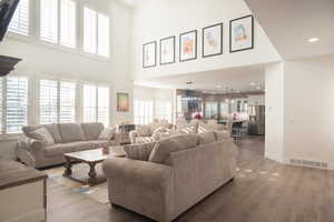 Living area with wood finished floors and a towering ceiling