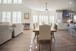 Dining room with dark wood-style flooring and recessed lighting