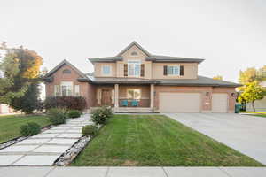 View of front of home featuring a porch, a front lawn, brick siding, and driveway