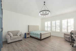 Bedroom featuring wood finished floors and a chandelier
