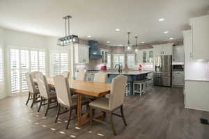 Dining space with recessed lighting and dark wood-type flooring