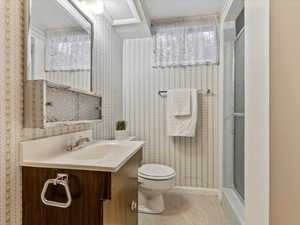 Full bathroom with vanity, a shower stall, and dark speckled floor