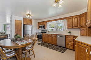 Kitchen featuring light countertops, brown cabinets, and appliances with stainless steel finishes