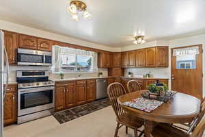 Kitchen with brown cabinets, stainless steel appliances, and plenty of natural light