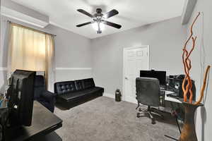 Office area featuring light colored carpet and ceiling fan