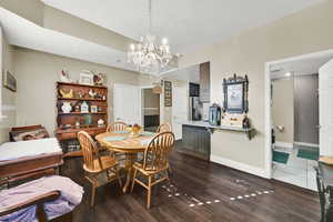 Dining area featuring a textured ceiling, dark wood-style floors, and a chandelier