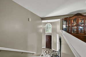 Tiled foyer entrance with baseboards and a towering ceiling