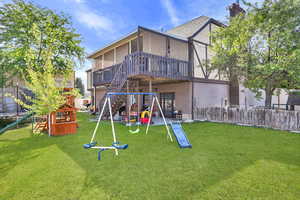 View of playground featuring a deck, a patio area, and stairs