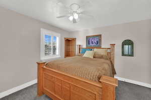Carpeted bedroom with baseboards and a ceiling fan