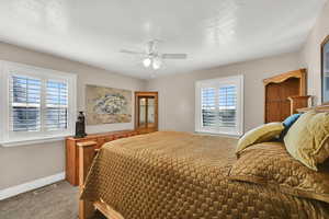 Carpeted bedroom featuring baseboards and ceiling fan