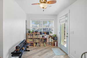 Sitting room with light wood-type flooring and ceiling fan