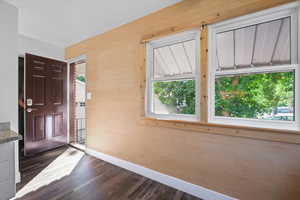 Foyer featuring dark wood-style flooring and baseboards