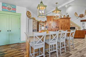 Kitchen 1 featuring brown cabinets, a kitchen island, light stone countertops, and a kitchen breakfast bar