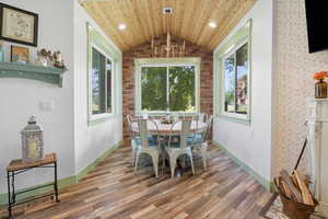 Dining area with lofted ceiling, wood finished floors, healthy amount of natural light, recessed lighting, and wood ceiling