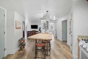 Dining room 3 with light wood-type flooring and a chandelier