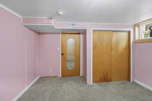 Unfurnished bedroom with a textured ceiling, carpet flooring, and a closet