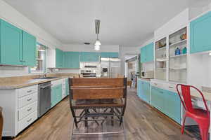 Kitchen 2 with decorative light fixtures, light countertops, stainless steel appliances, dark wood finished floors, and decorative backsplash