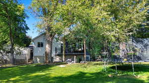 View of yard featuring a trampoline and a wooden deck