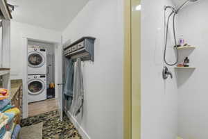 Washroom featuring stacked washing machine and dryer