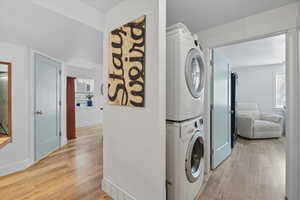 Laundry room 3 featuring light wood-type flooring and stacked washer and clothes dryer