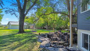 View of grassy yard featuring a trampoline