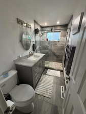 Bathroom with vanity, a shower stall, and dark wood-style floors