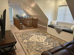 Additional living space with light carpet and lofted ceiling