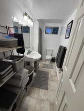 Bathroom featuring a textured ceiling and light tile patterned floors