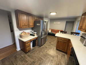 Kitchen with a peninsula, light countertops,  dishwasher, and a breakfast bar area