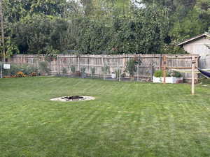 Fenced backyard with an outdoor fire pit