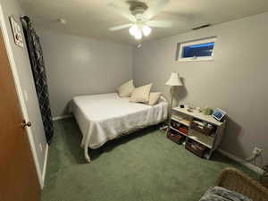 Carpeted bedroom featuring a ceiling fan and baseboards