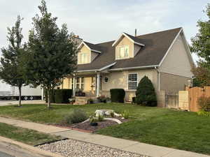 Cape cod-style house with brick siding, a porch, roof with shingles, and a chimney