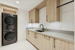 Washroom featuring estacked washer and dryer, light tile patterned floors, and recessed lighting