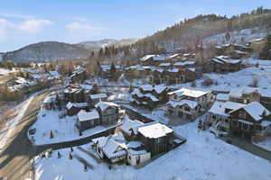 Snowy aerial view with a mountain view and a residential view