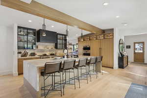 Kitchen featuring a kitchen breakfast bar, plenty of natural light, hanging light fixtures, a spacious island, and recessed lighting