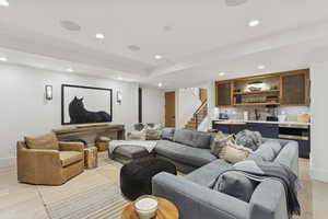 Home theater featuring recessed lighting, light wood finished floors, and wet bar